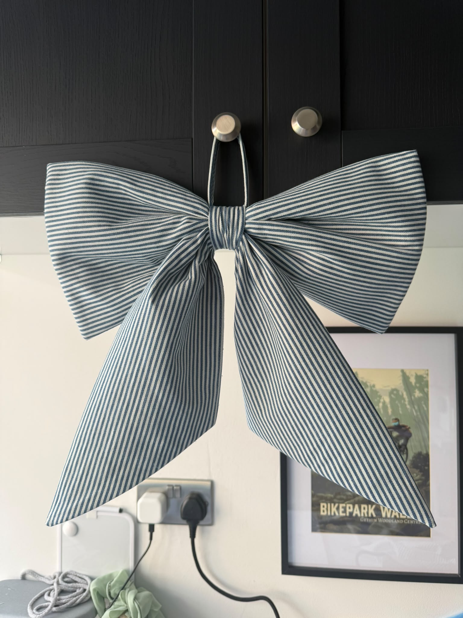 Designer’s oversized blue and white striped fabric bow with long pointed tails